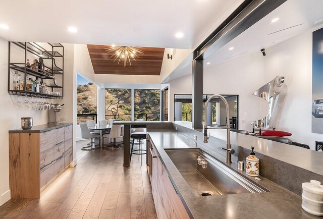 kitchen featuring vaulted ceiling, sink, dark wood-type flooring, wood ceiling, and a notable chandelier