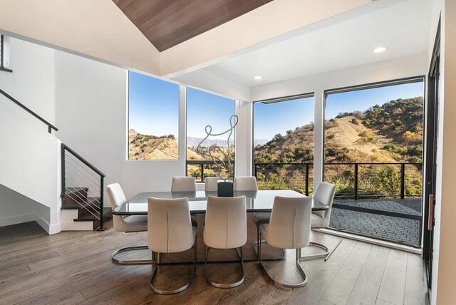 dining space featuring a mountain view, hardwood / wood-style floors, lofted ceiling, and wood ceiling