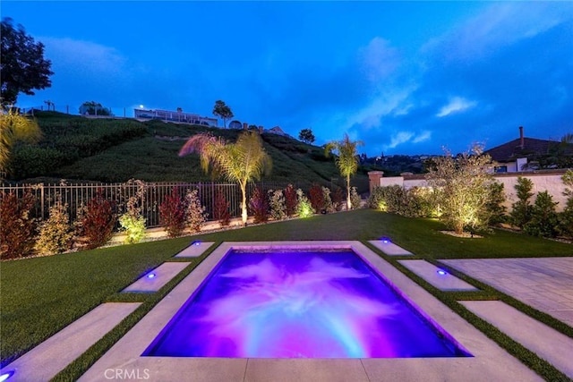 view of pool with a hot tub and a lawn