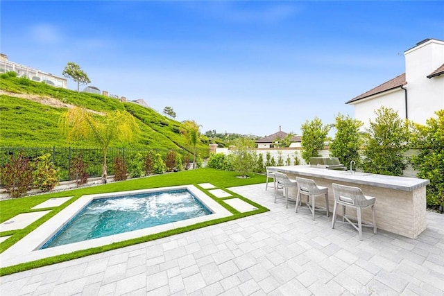 view of pool featuring a patio, an outdoor bar, and a lawn