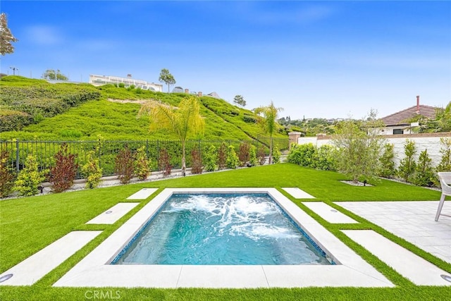 view of swimming pool featuring a patio and a yard