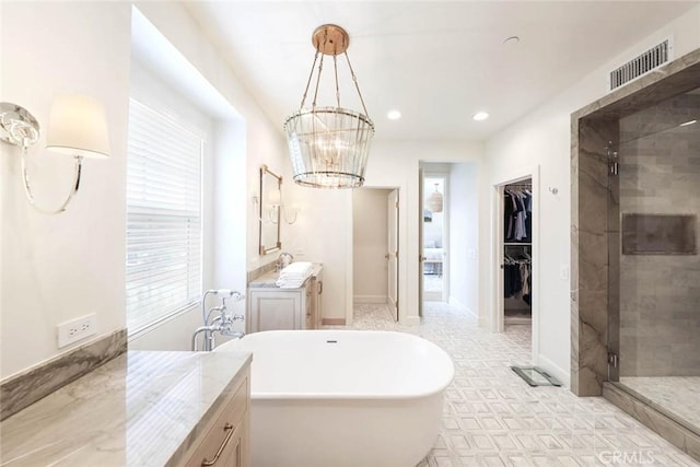 bathroom featuring a chandelier, shower with separate bathtub, and vanity