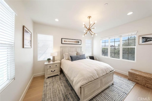 bedroom featuring light hardwood / wood-style flooring and a chandelier