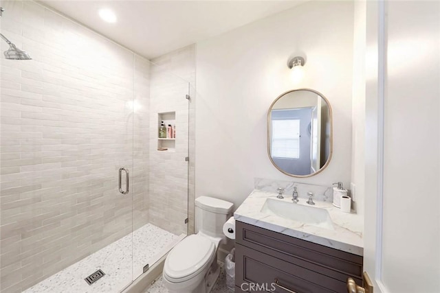 bathroom with toilet, walk in shower, and vanity