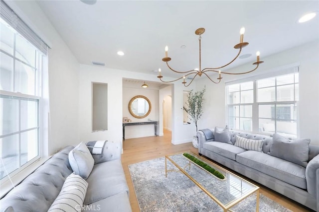 living room featuring a chandelier and light hardwood / wood-style flooring