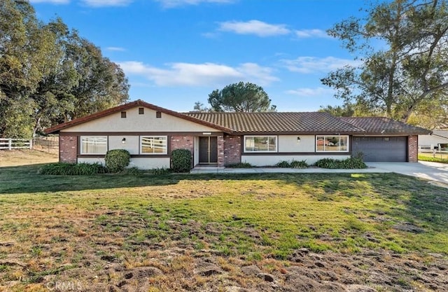 single story home featuring a garage and a front lawn