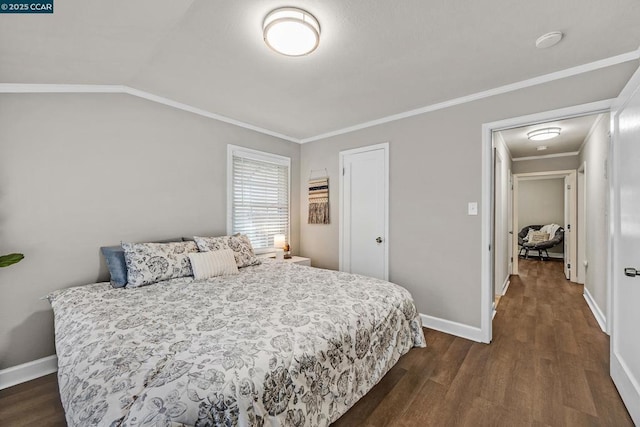 bedroom with vaulted ceiling, crown molding, and dark hardwood / wood-style floors