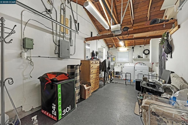 basement featuring electric panel, water heater, and washer and clothes dryer