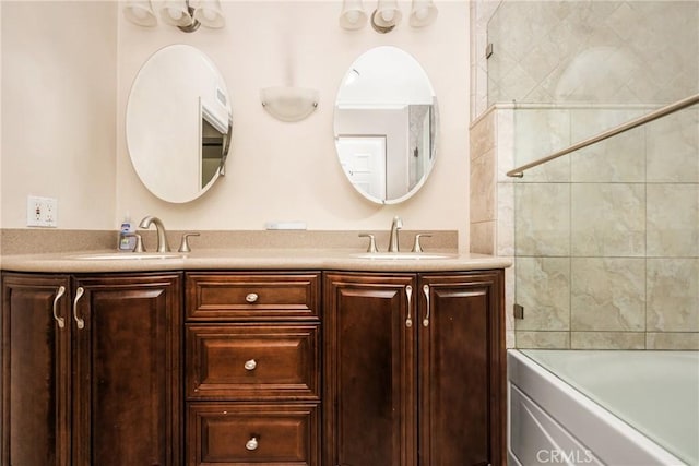 bathroom with tiled shower / bath combo and vanity