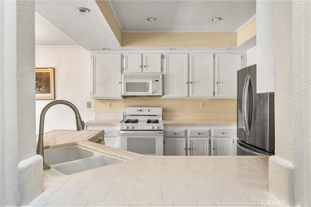 kitchen featuring ornamental molding, sink, white cabinets, and white appliances