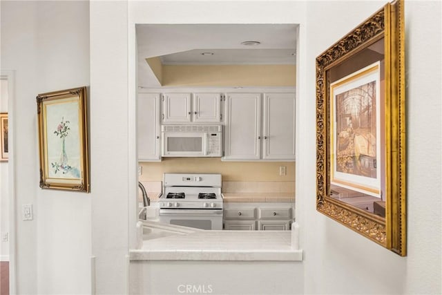 kitchen featuring white cabinetry and white appliances