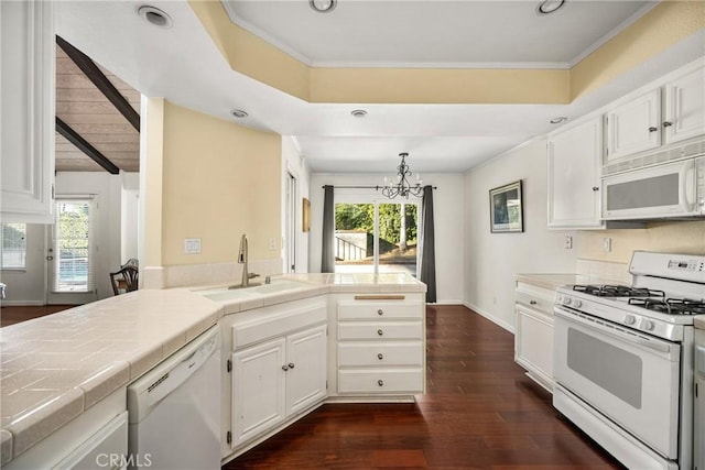 kitchen featuring dark wood-type flooring, sink, white cabinetry, hanging light fixtures, and white appliances