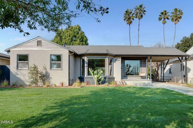 back of property with a lawn and a carport