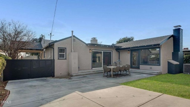 back of house with central air condition unit, a lawn, and a patio