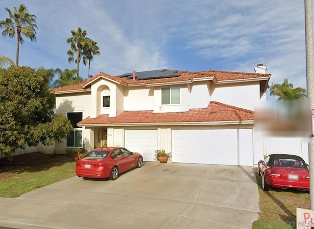 mediterranean / spanish home featuring a garage and solar panels