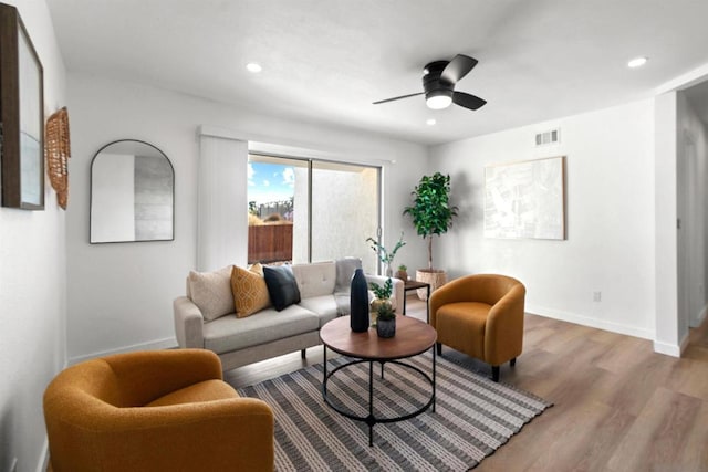 living room featuring light wood-type flooring and ceiling fan