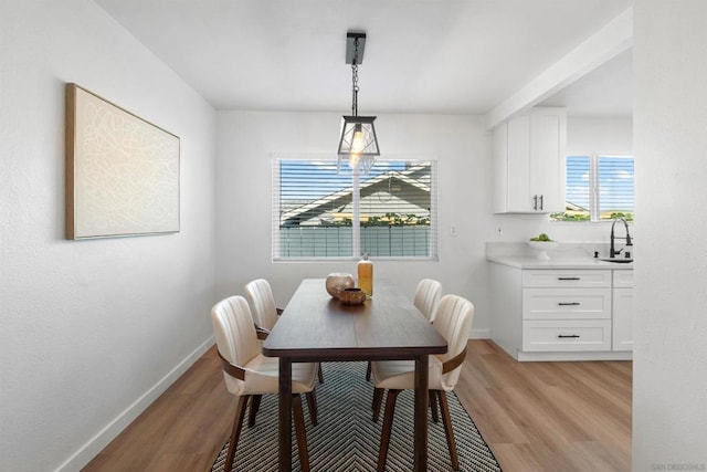 dining space with sink and light wood-type flooring