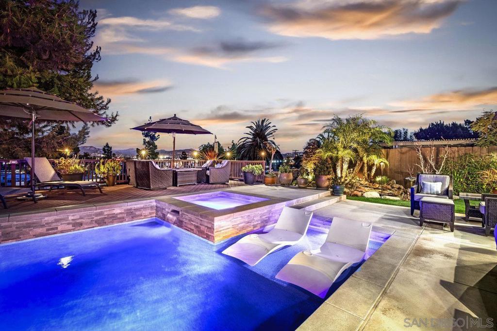 pool at dusk featuring an in ground hot tub, an outdoor living space, and a patio