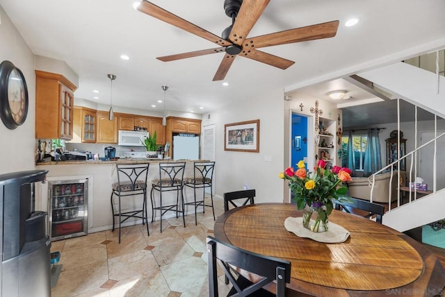 dining space with ceiling fan and beverage cooler