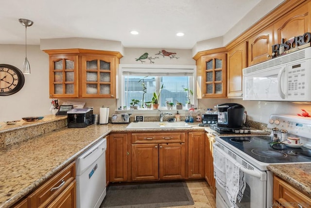 kitchen featuring sink, decorative light fixtures, white appliances, and light stone countertops