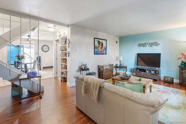 living room with built in shelves and wood-type flooring