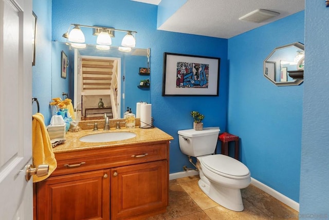 bathroom with toilet, tile patterned floors, and vanity