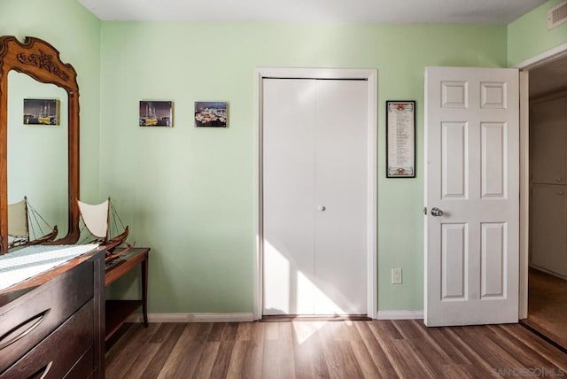 bedroom featuring a closet and dark hardwood / wood-style flooring