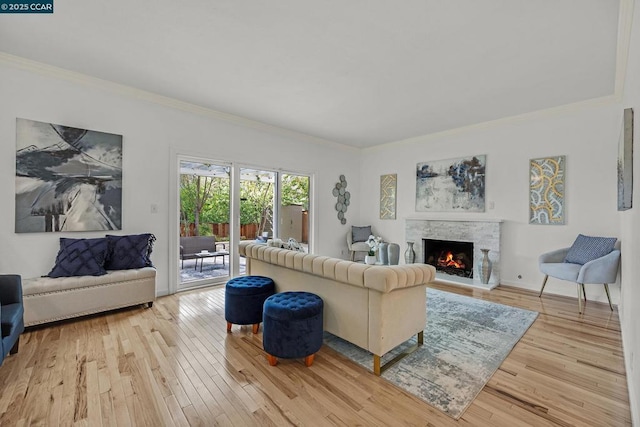 living room featuring a fireplace, light wood-type flooring, and ornamental molding