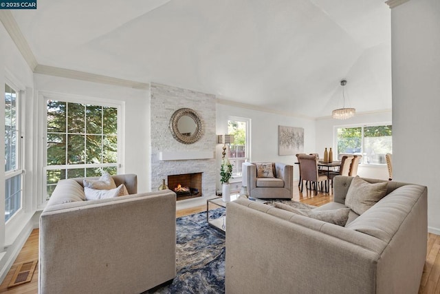 living room featuring hardwood / wood-style flooring, a fireplace, vaulted ceiling, and a healthy amount of sunlight