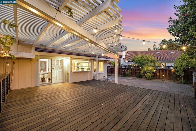 deck at dusk featuring a patio and a pergola