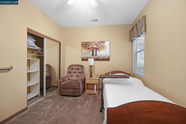 bedroom with ceiling fan, dark carpet, and a closet