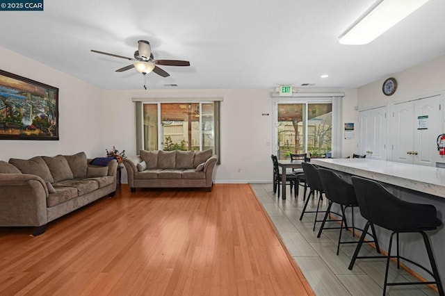 living room with light wood-type flooring and ceiling fan