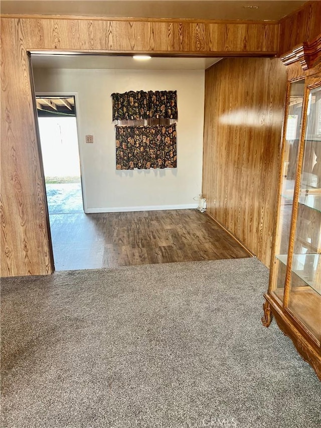 empty room with carpet and wood walls