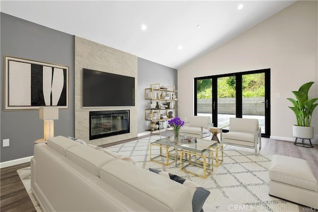 living room featuring wood-type flooring, high vaulted ceiling, and a fireplace