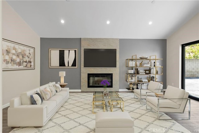 living room with a fireplace, light hardwood / wood-style floors, and vaulted ceiling