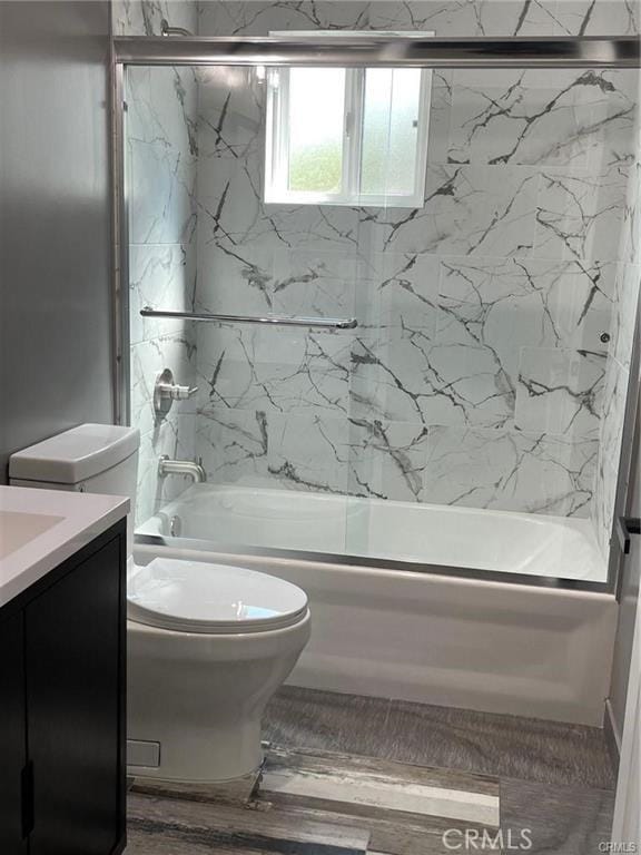 full bathroom featuring vanity, toilet, and combined bath / shower with glass door