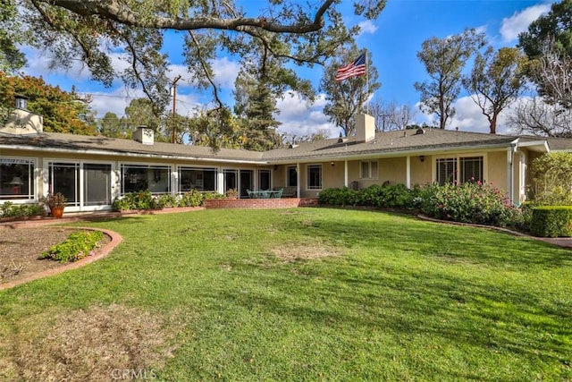 rear view of property featuring a lawn