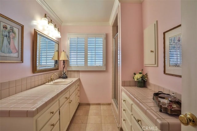 bathroom featuring vanity, a shower with shower door, crown molding, and tile patterned flooring