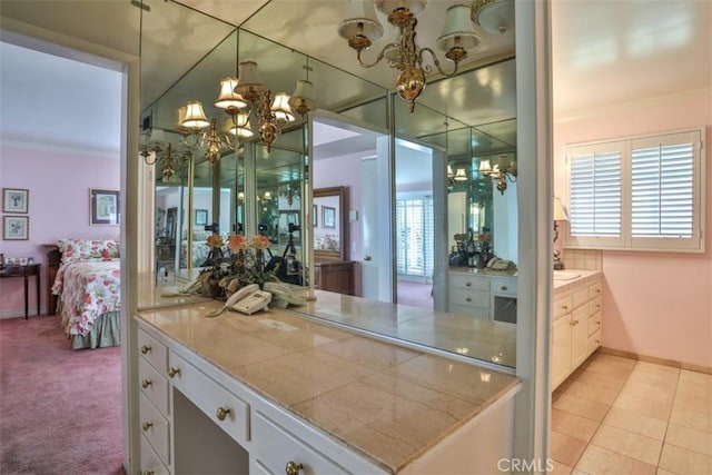 bathroom with vanity, a chandelier, crown molding, and tile patterned flooring