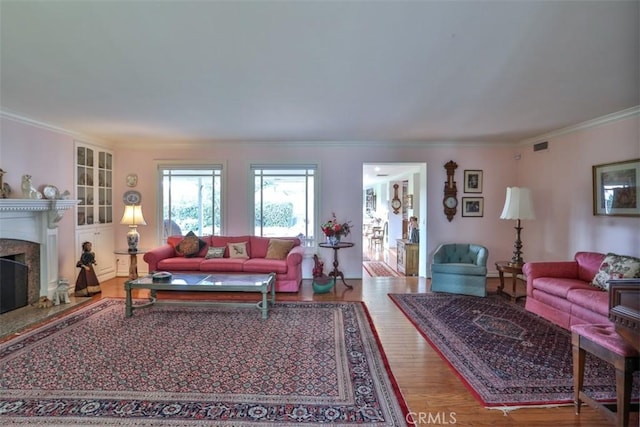 living room with ornamental molding, hardwood / wood-style flooring, and a premium fireplace