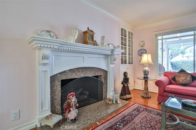 sitting room featuring a fireplace, hardwood / wood-style floors, and ornamental molding