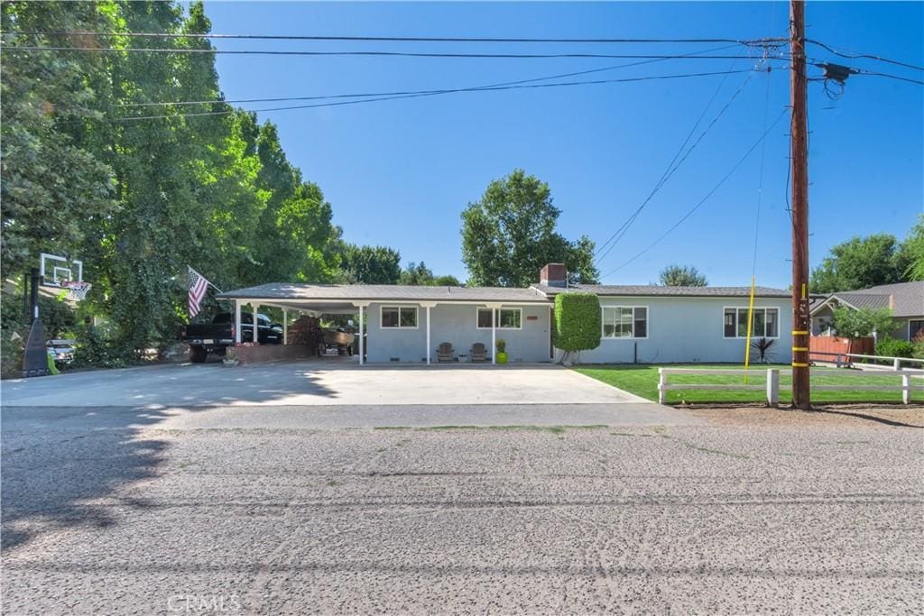 ranch-style house with a carport and a front lawn