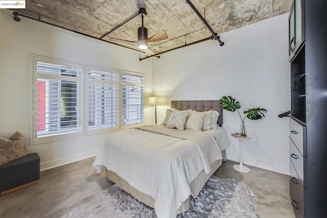 bedroom with ceiling fan and concrete floors