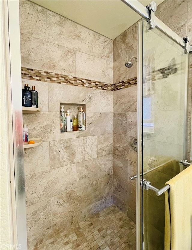 bathroom featuring a shower with shower door