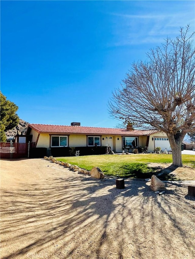 ranch-style home with a garage and a front lawn