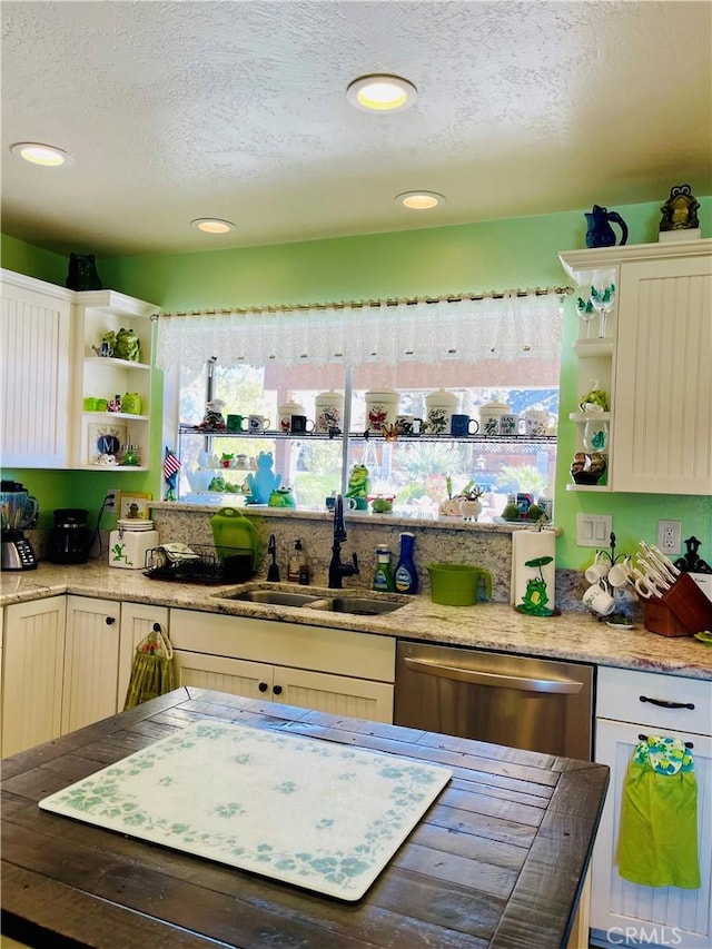 kitchen featuring sink, a textured ceiling, and dishwasher