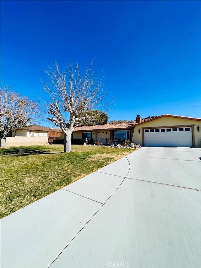 ranch-style house featuring a garage and a front lawn