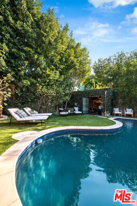 view of swimming pool featuring a yard