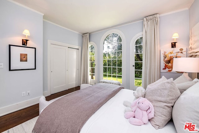 bedroom featuring a closet, hardwood / wood-style flooring, and crown molding