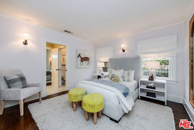 bedroom with dark hardwood / wood-style flooring and ornamental molding